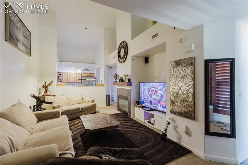 Image 15 of 35: Vaulted ceilings enhance this open-concept living space, featuring a built-