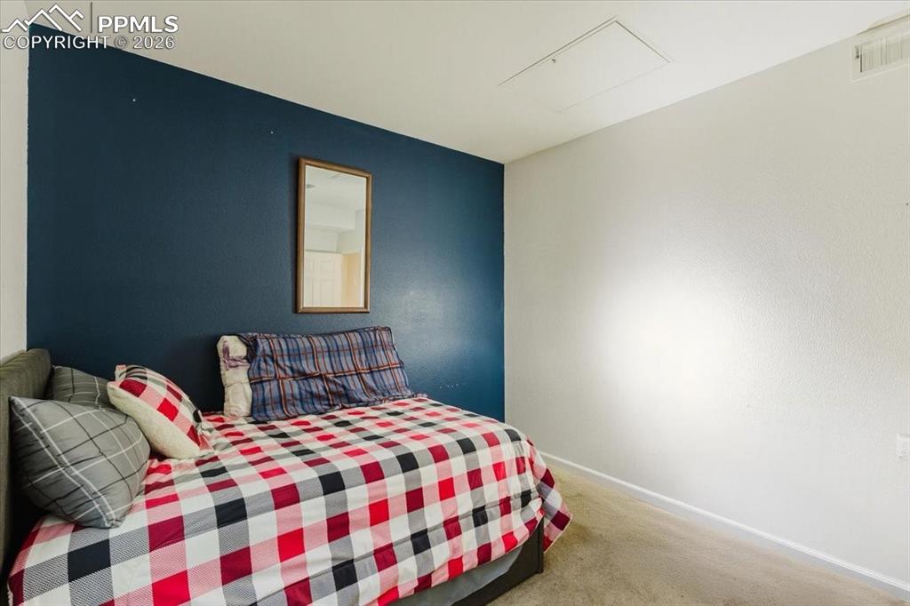 Image 16 of 35: Carpeted room featuring a dark accent wall, white textured walls, white tri