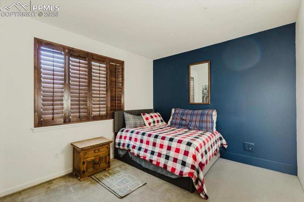 Image 17 of 35: Interior room featuring wood plantation shutters, a dark accent wall, and n