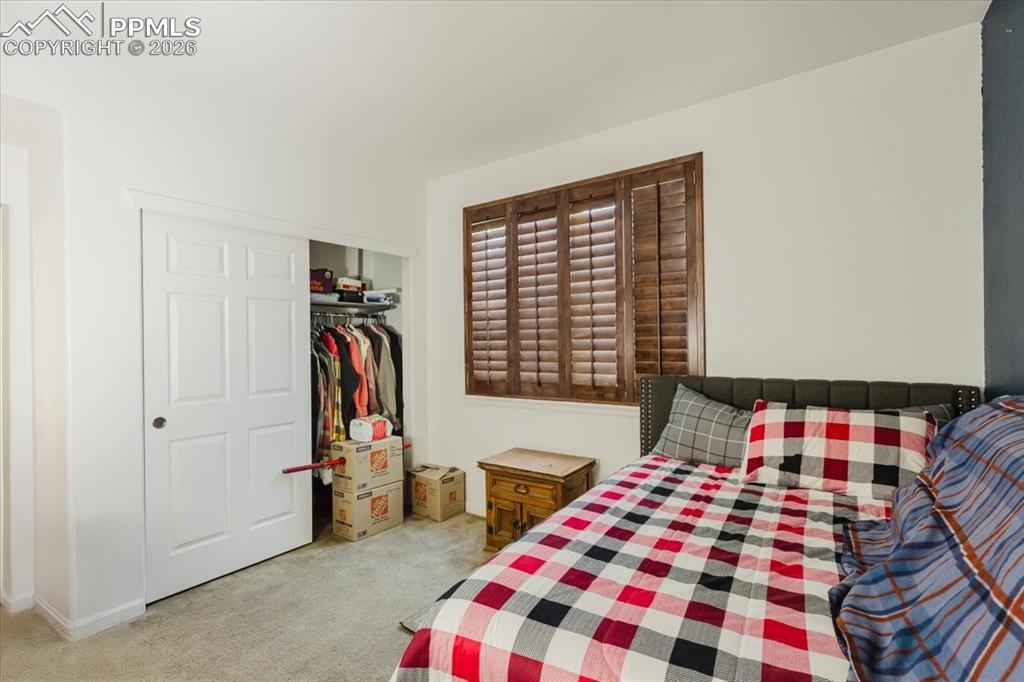 Image 18 of 35: Room featuring a window with wood plantation shutters, light-toned carpetin