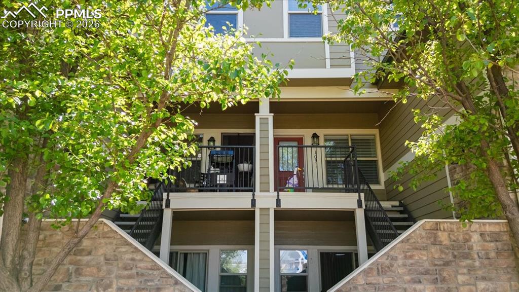 Image 2 of 35: Multi-story exterior with horizontal siding and stone veneer accents