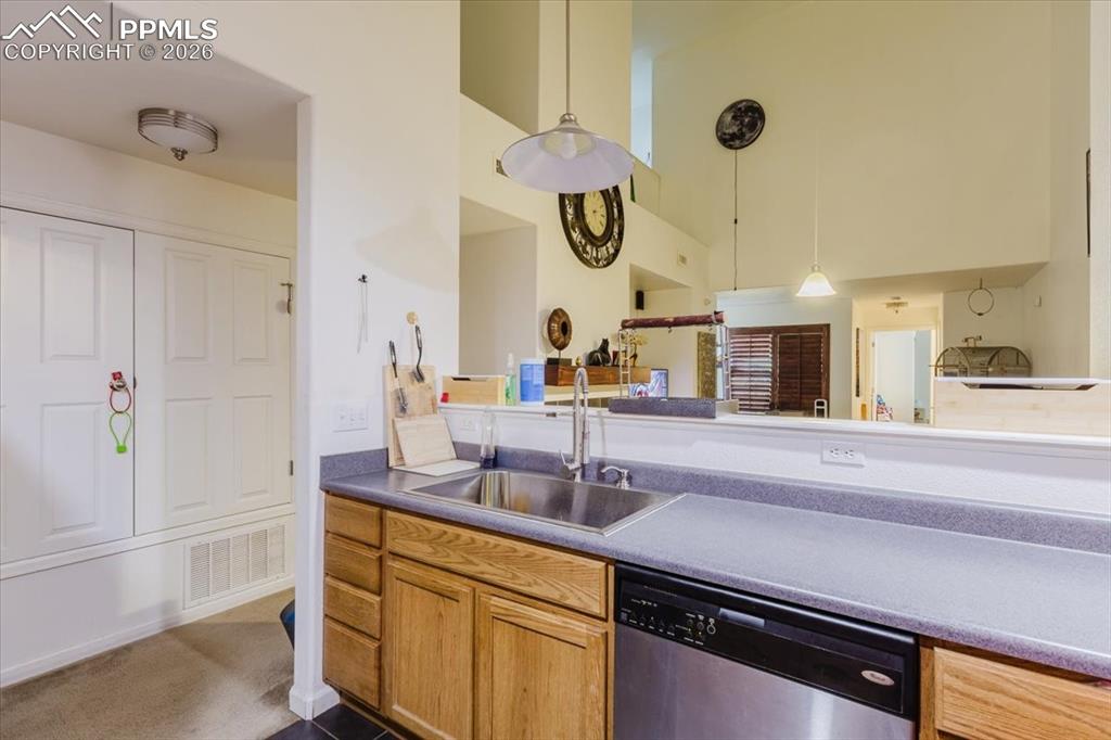 Image 21 of 35: Kitchen space featuring wood-finish cabinetry, stainless steel sink, and a 