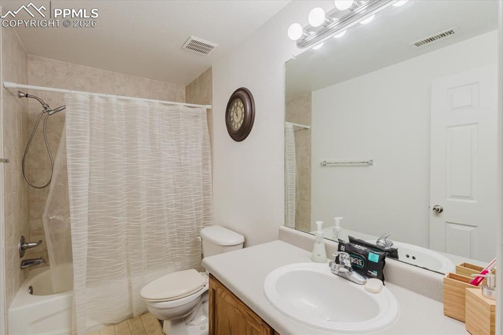 Image 23 of 35: Full bathroom featuring a shower-over-tub combination with tiled surround, 