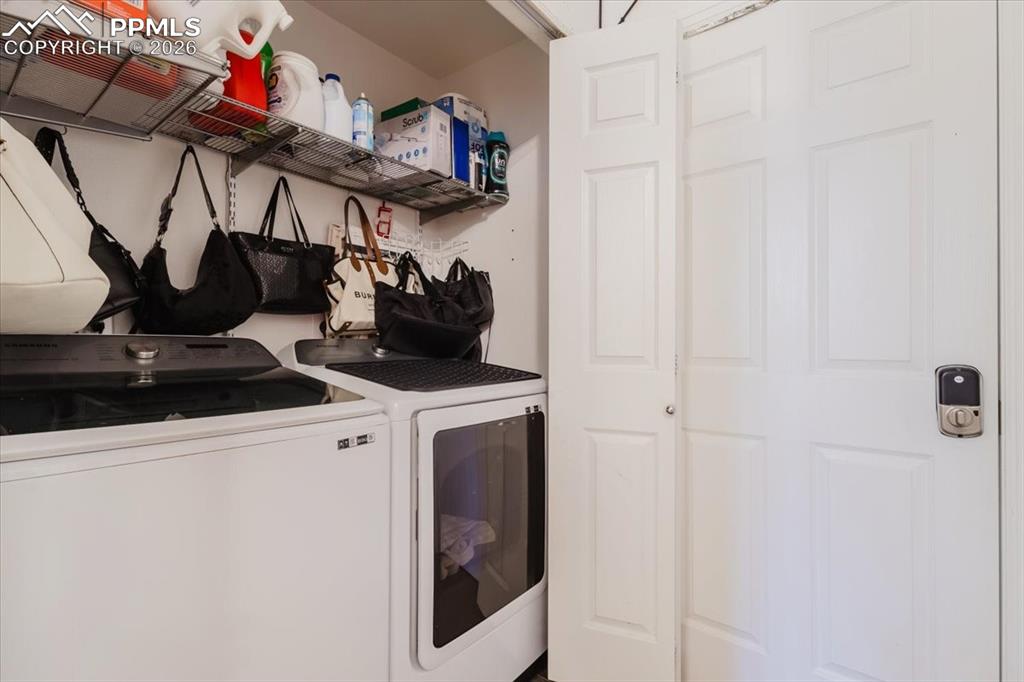 Image 25 of 35: Dedicated laundry area featuring a white washing machine and dryer, overhea