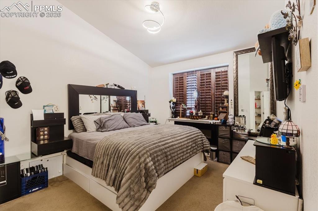 Image 26 of 35: Bedroom featuring wood-finish plantation shutters, a mirrored bed frame, an