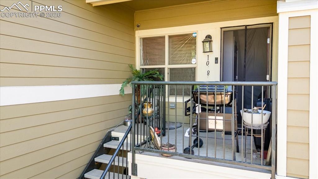 Image 3 of 35: Private exterior patio featuring a privacy screen door, a wall-mounted ligh