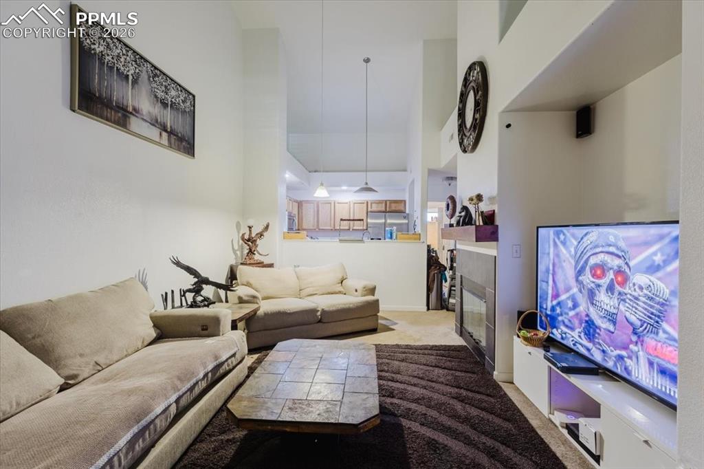 Image 35 of 35: Living area with high ceilings, recessed lighting, and an integrated firepl