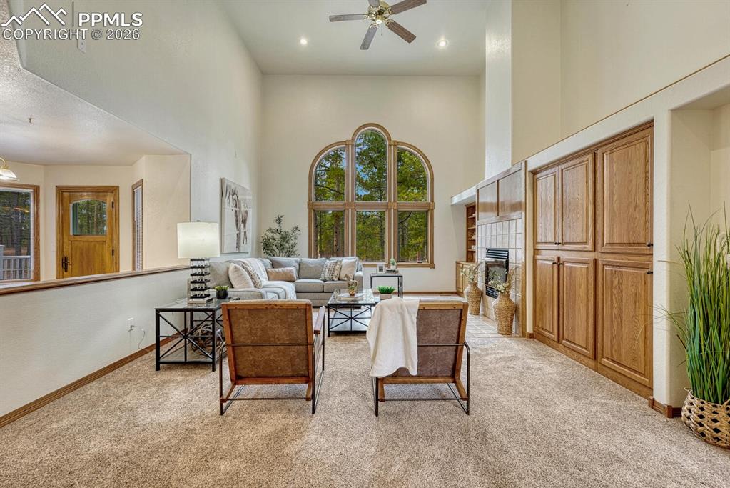 Image 12 of 50: The inviting Family Room has high ceilings, a lighted ceiling fan, and plus