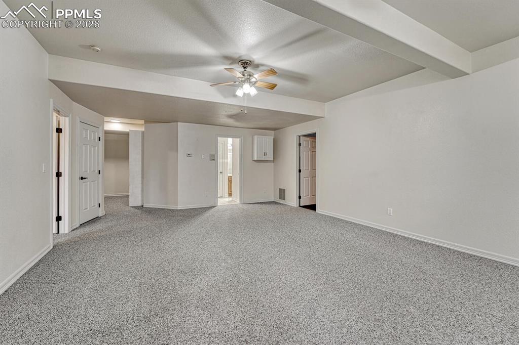 Image 37 of 50: The large Basement Rec Room has carpet and a lighted ceiling fan and is per