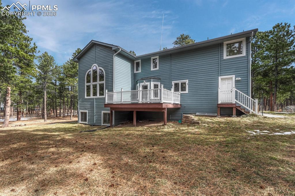 Image 43 of 50: Rear view of home and backyard with composite deck.