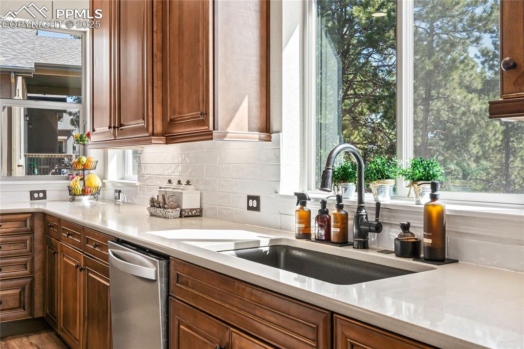 Image 12 of 50: Beautiful view to the pine tree filled backyard from the kitchen sink