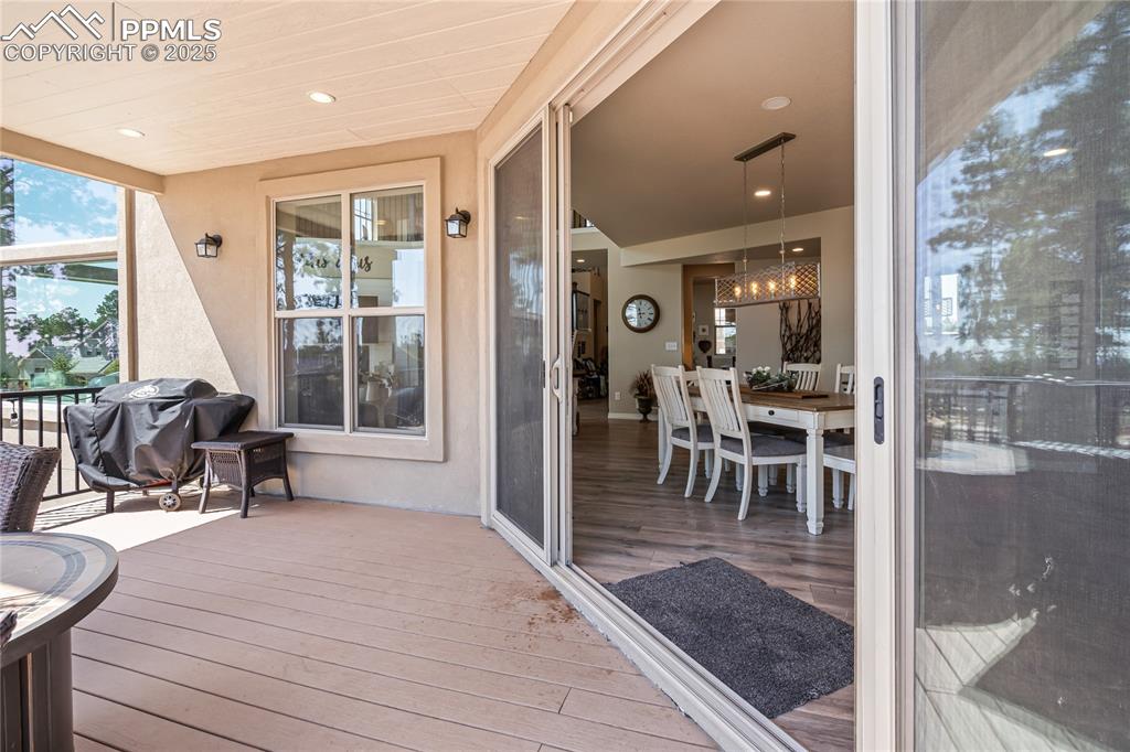 Image 16 of 50: Large slider doors lead to covered back deck with access to the yard