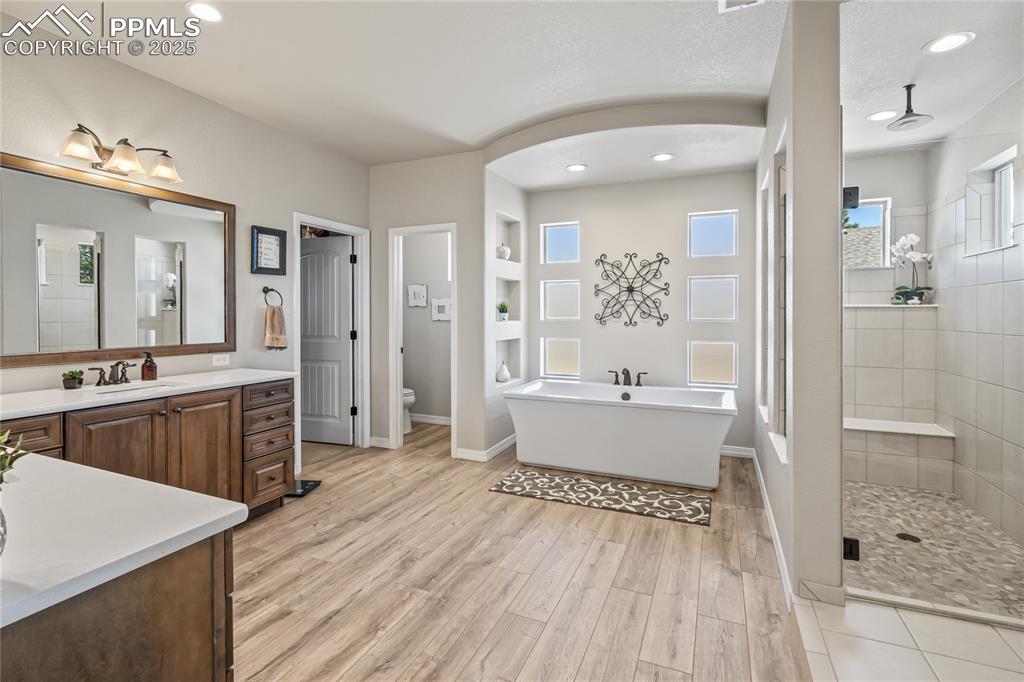 Image 20 of 50: Primary Ensuite, LVP floors, tile entrance to shower, Quartz countertops, 2
