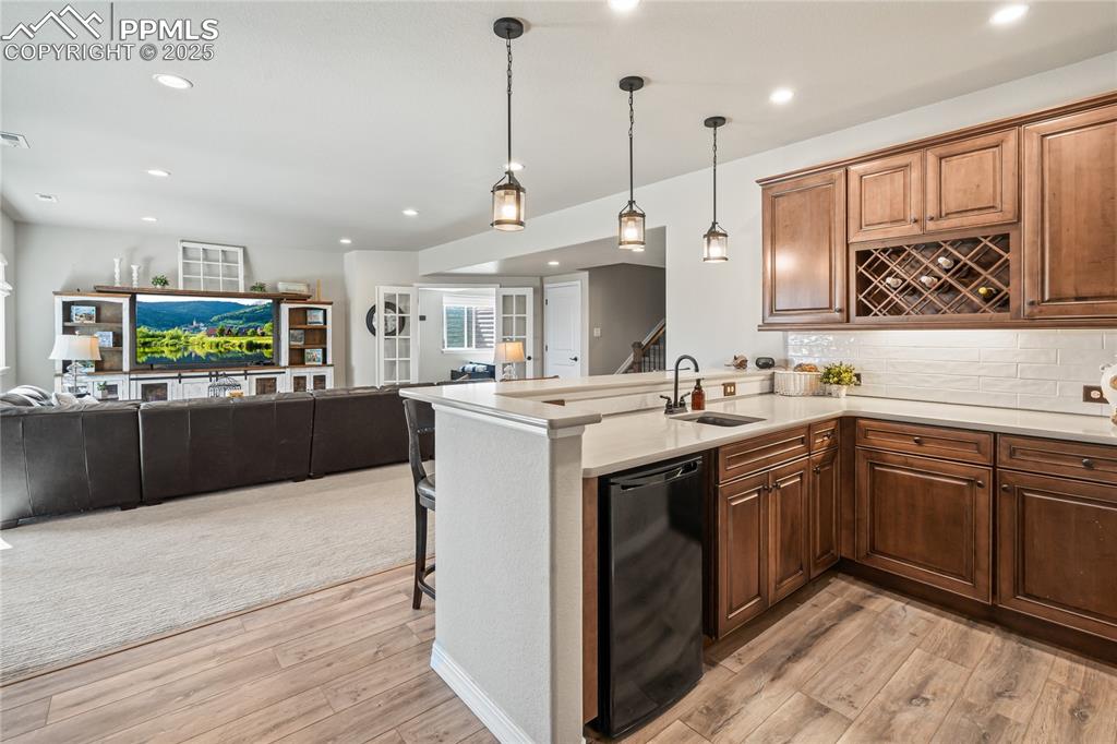 Image 35 of 50: Basement wet bar, quartz, LVP flooring, wine rack, Bar Top Seating, and Min
