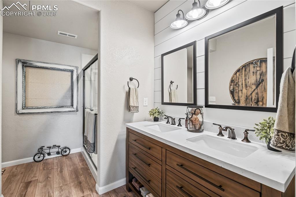 Image 37 of 50: 3/4 bathroom off basement living. Dual vanity, quartz, LVP flooring, tile s