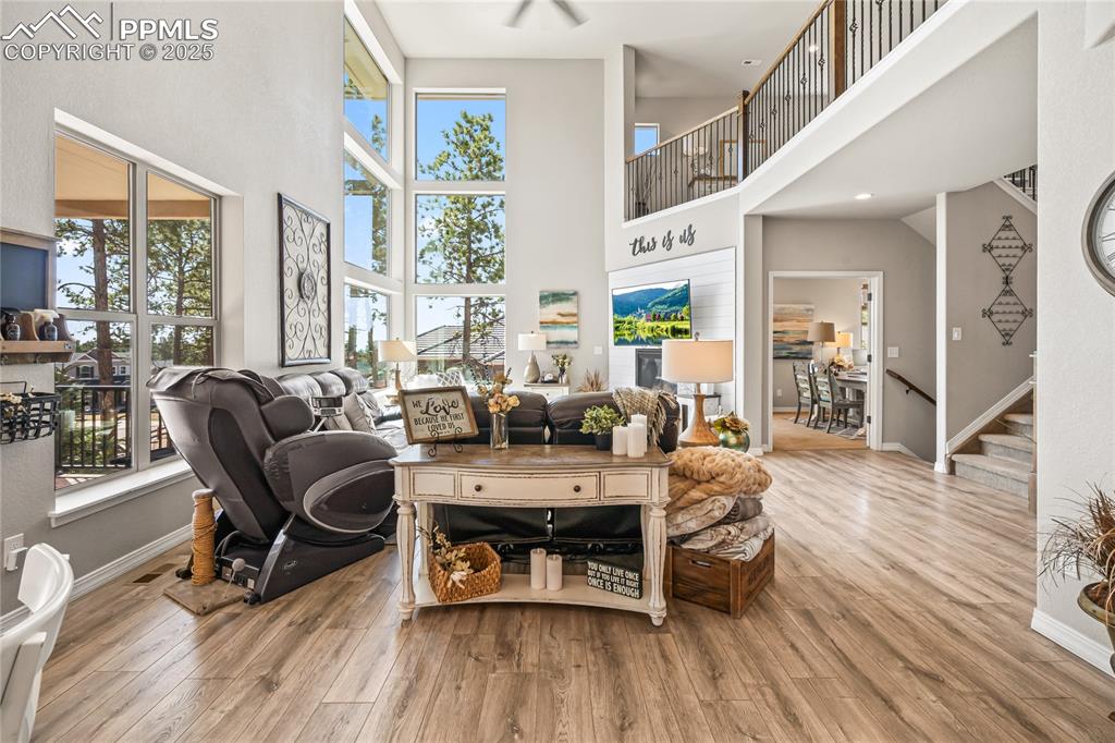 Image 5 of 50: Living area featuring a towering ceiling, wood finished floors, stairs, and