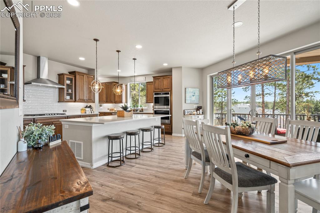 Image 7 of 50: Open concept informal dining room adjacent to the kitchen and back deck