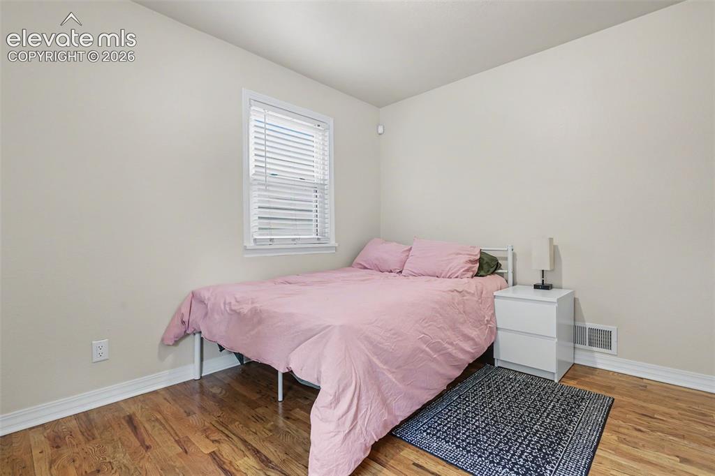 Image 12 of 36: Warm-toned wood-finish flooring complements light-colored walls