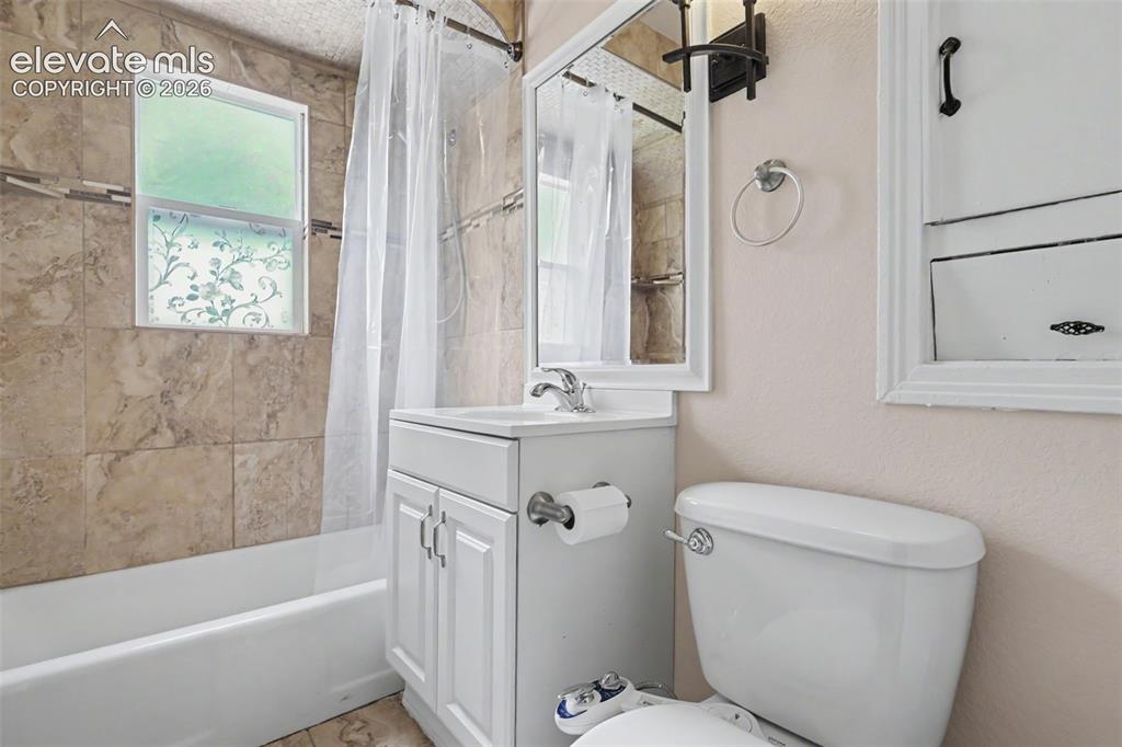 Image 13 of 36: Light-filled room featuring wood-finish flooring, neutral wall paint, white