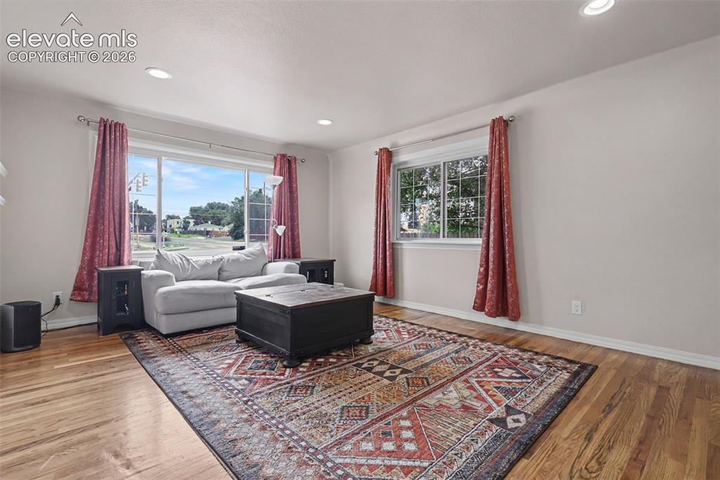 Image 5 of 36: Living area featuring wood-finish flooring, recessed lighting, and arched d