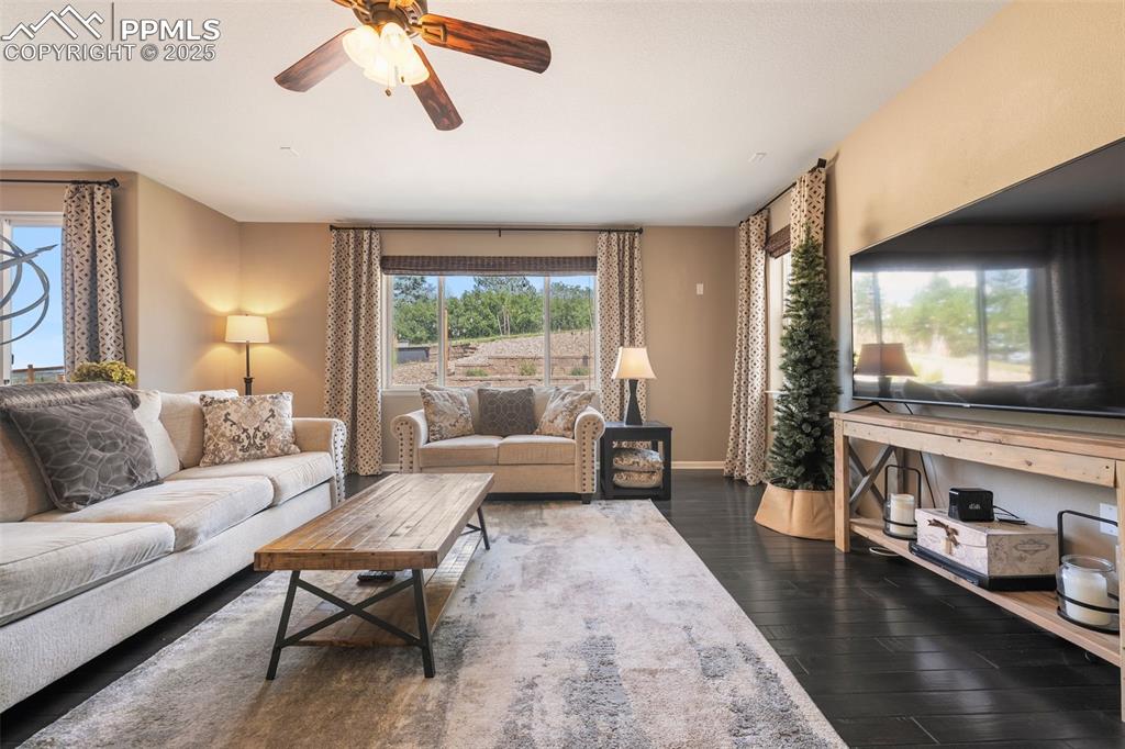 Image 14 of 46: Living area with dark wood-style floors, plenty of natural light, and ceili