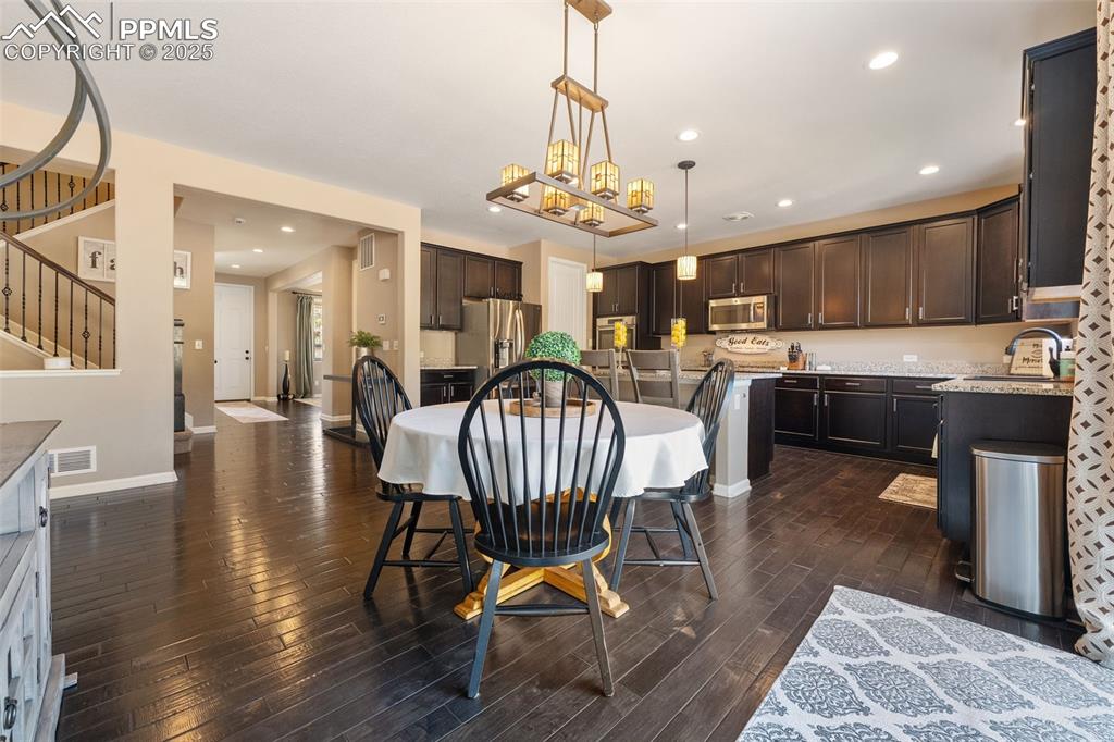 Image 19 of 46: Dining space featuring recessed lighting, dark wood-type flooring, stairway