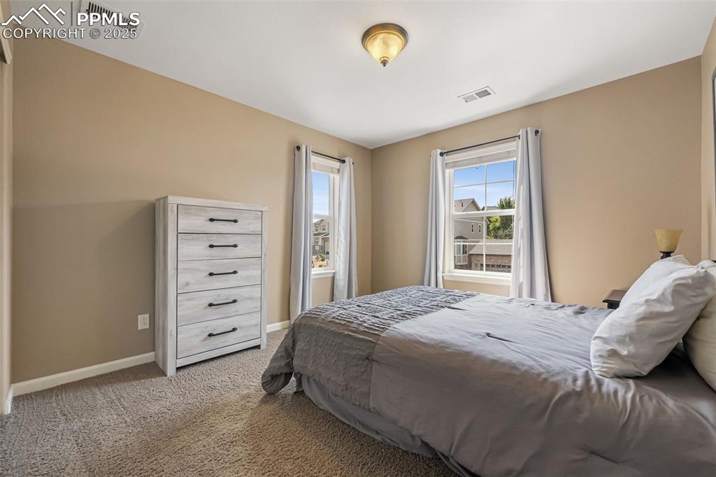 Image 20 of 46: Bedroom with carpet floors and baseboards