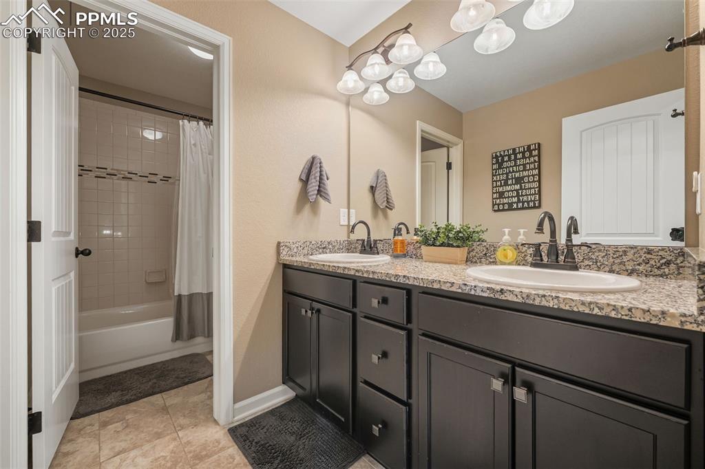Image 26 of 46: Bathroom featuring shower / bath combo with shower curtain, double vanity, 
