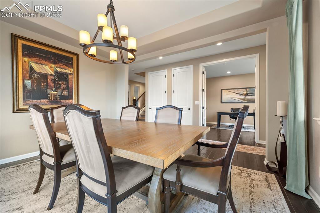 Image 6 of 46: Dining room featuring dark wood-style floors, a chandelier, recessed lighti