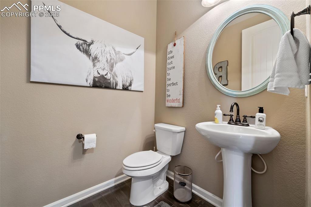 Image 7 of 46: Half bath with a textured wall and dark wood-type flooring