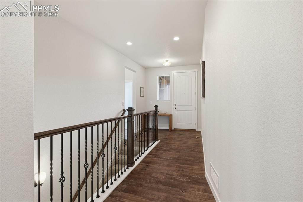 Image 14 of 39: Beautiful entry with wrought iron pickets and plank flooring!