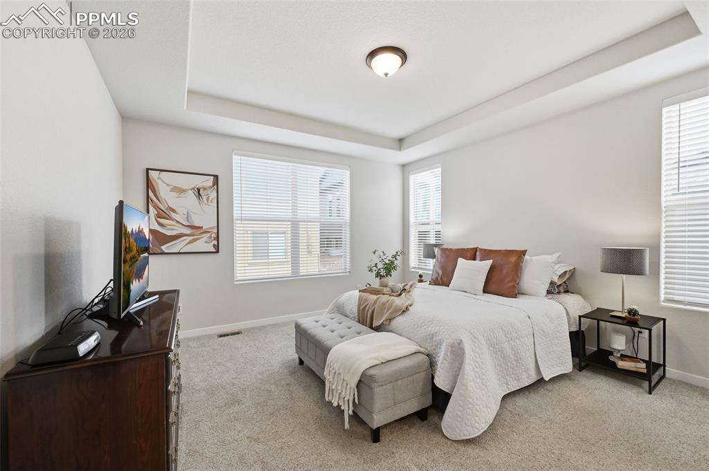 Image 15 of 39: Private master bedroom retreat with a coffered ceiling and light colored ca