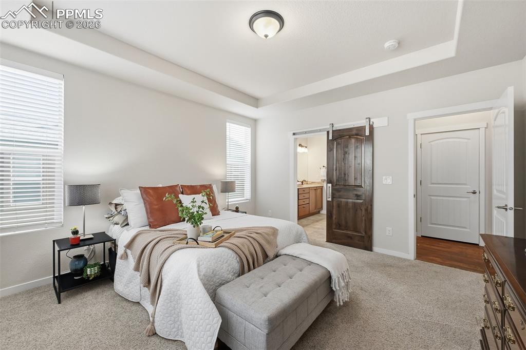 Image 16 of 39: Private master bedroom retreat has a barn door to the  bath!
