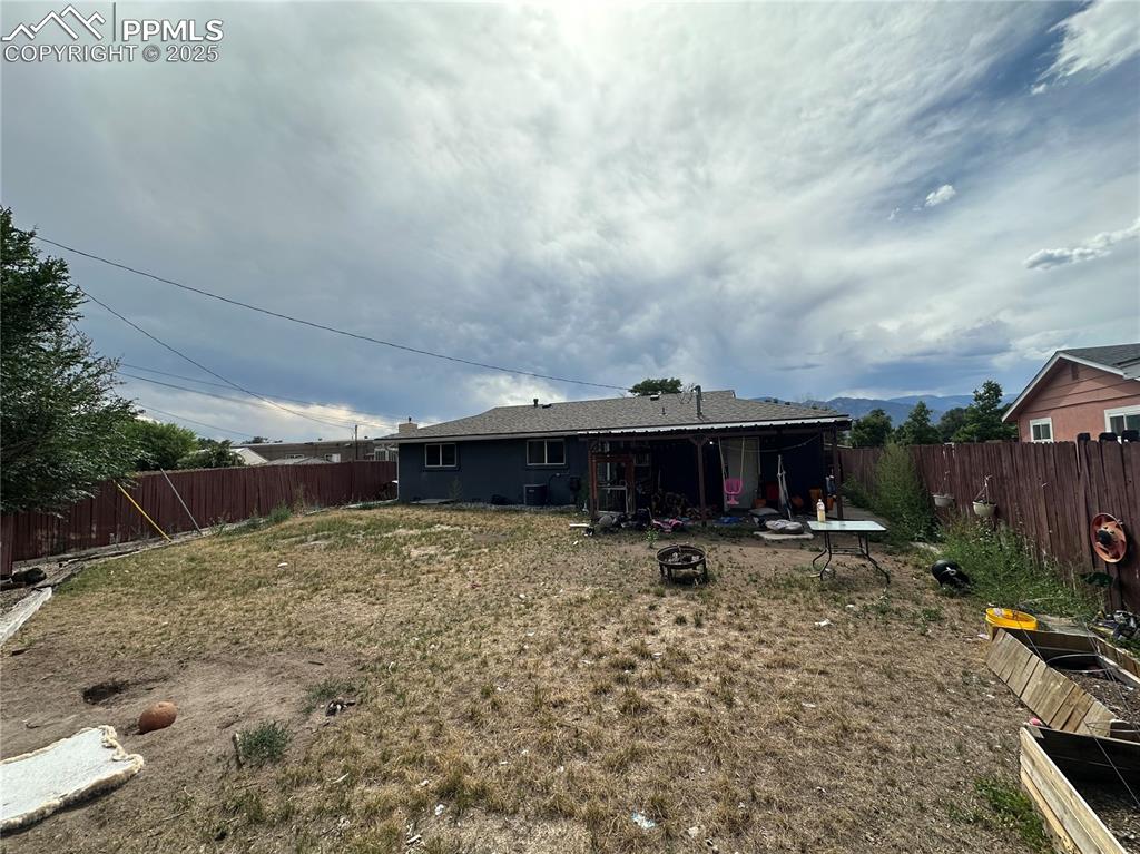 Image 13 of 13: Fenced backyard featuring a fire pit
