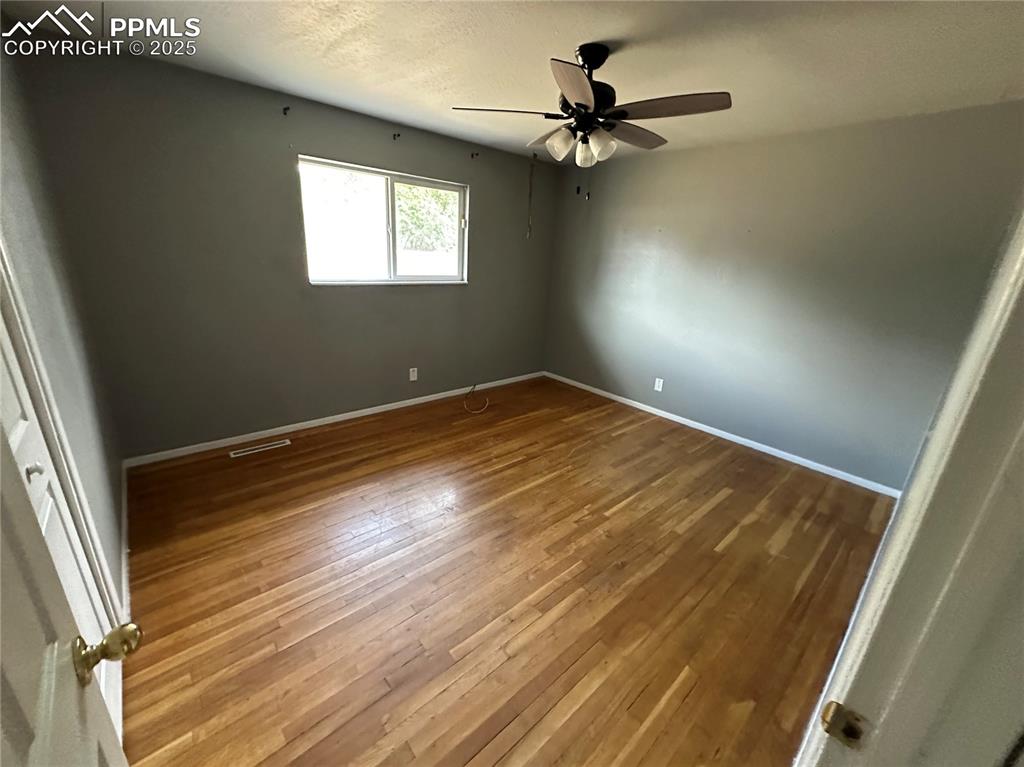 Image 7 of 13: Unfurnished bedroom with wood-type flooring, a textured ceiling, and ceilin