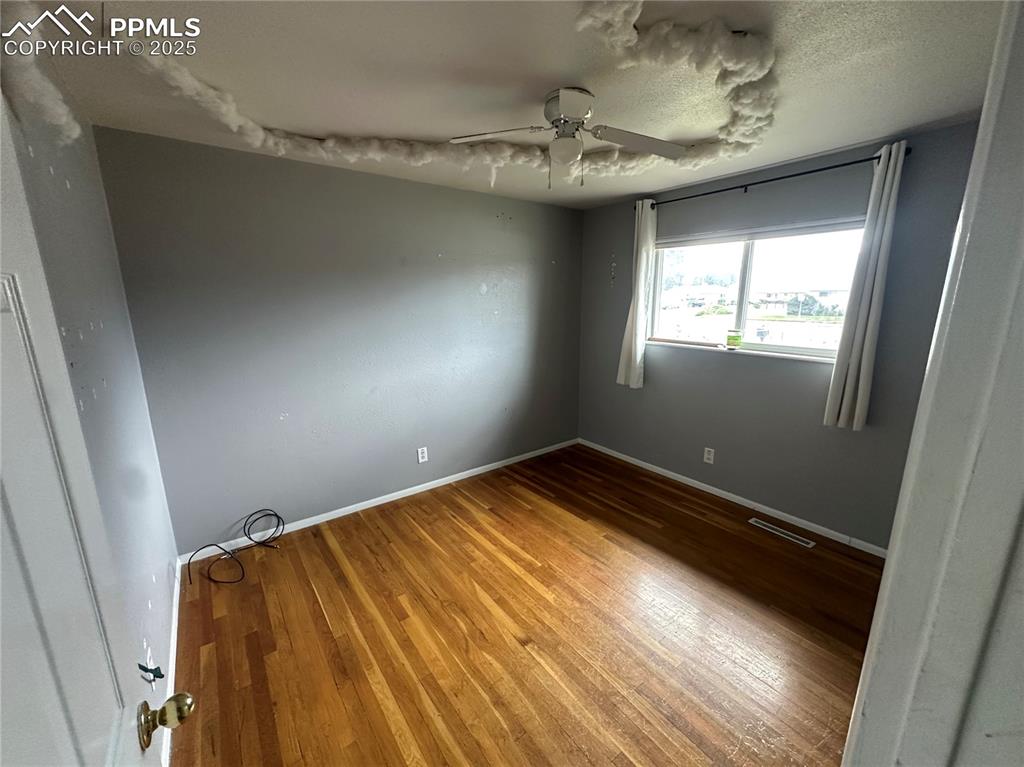 Image 8 of 13: Unfurnished room featuring wood-type flooring and a ceiling fan