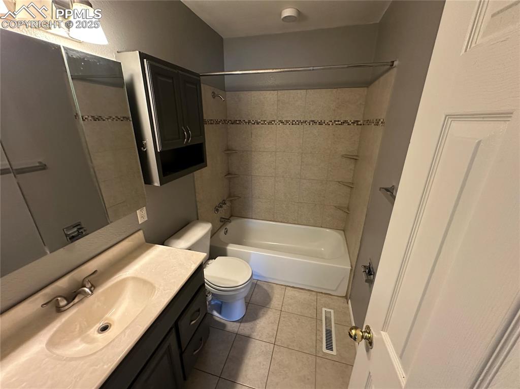 Image 9 of 13: Bathroom featuring vanity, tile patterned flooring, and shower combination