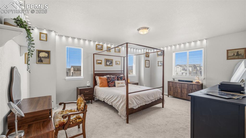 Image 18 of 37: Bedroom featuring light carpet and a textured ceiling