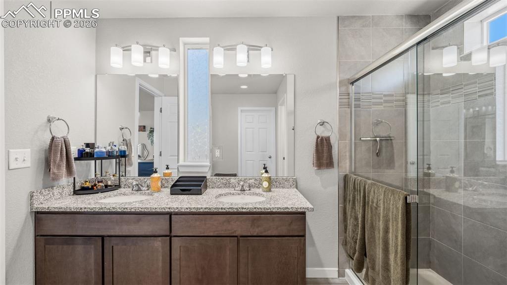 Image 22 of 37: Bathroom featuring double vanity and a stall shower