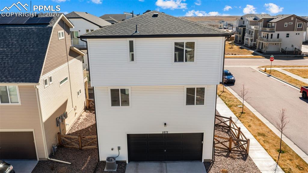 Image 32 of 37: Rear view of house featuring a gate, a residential view, a garage, a shingl