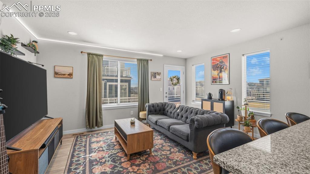 Image 4 of 37: Living area featuring wood finished floors and recessed lighting