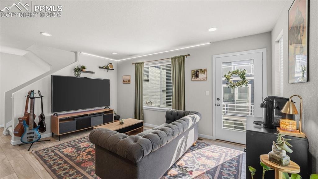 Image 5 of 37: Living room with light wood-style floors and recessed lighting