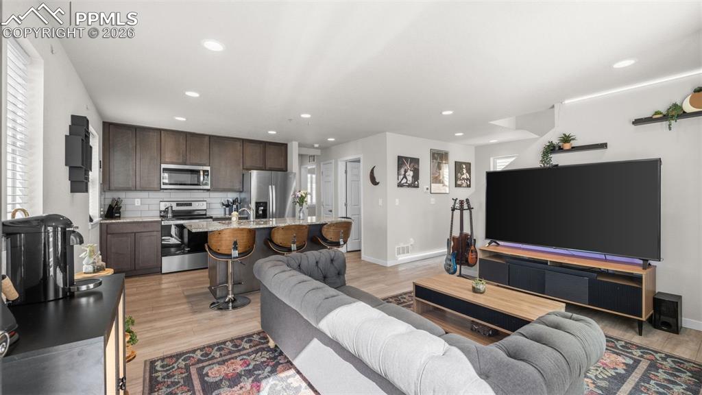 Image 6 of 37: Living room with light wood-type flooring and recessed lighting