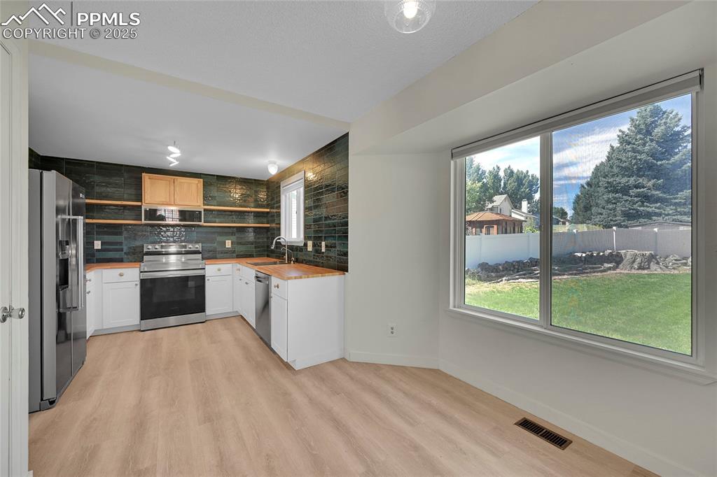 Image 17 of 39: Kitchen featuring appliances with stainless steel finishes, tasteful backsp