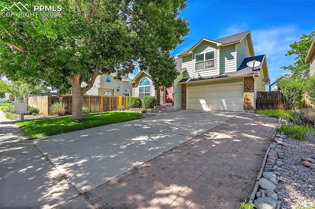 Image 2 of 39: Traditional-style home featuring driveway, brick siding, a garage, and roof