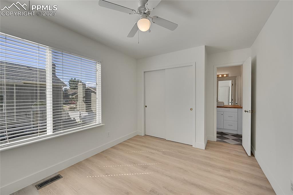 Image 27 of 39: Unfurnished bedroom featuring light wood-style floors, a closet, ceiling fa
