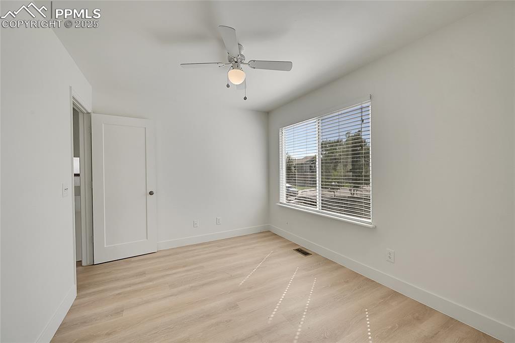Image 28 of 39: Unfurnished room with light wood finished floors and a ceiling fan