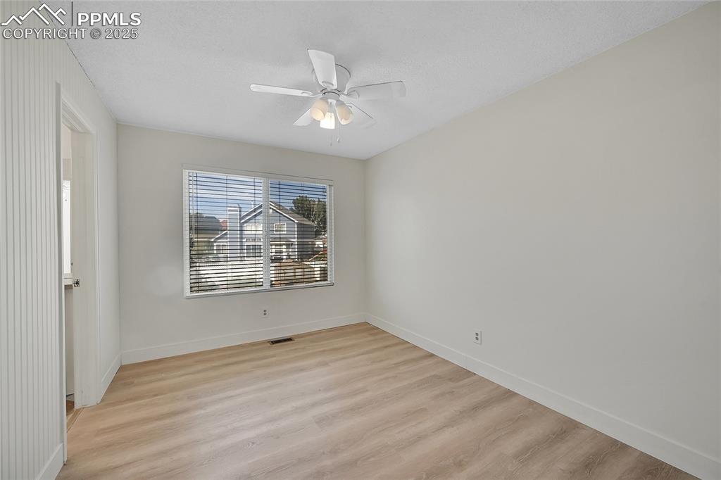 Image 29 of 39: Unfurnished room featuring light wood finished floors, ceiling fan, and a t