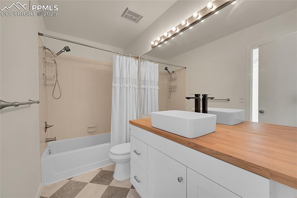 Image 31 of 39: Full bathroom with shower / tub combo with curtain and vanity