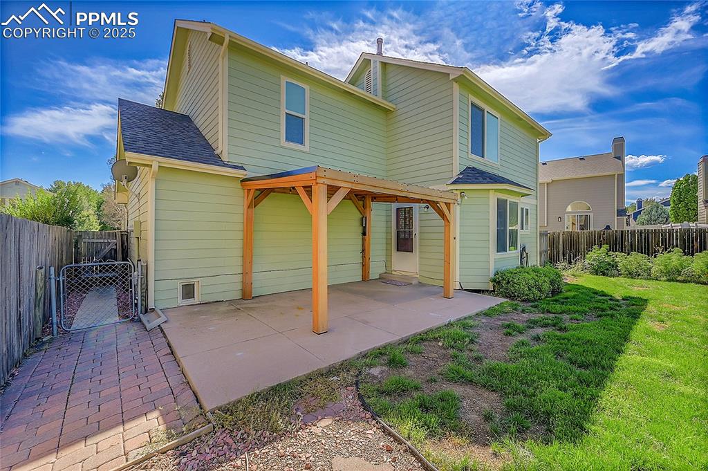 Image 34 of 39: Rear view of house featuring a fenced backyard, a shingled roof, a patio ar